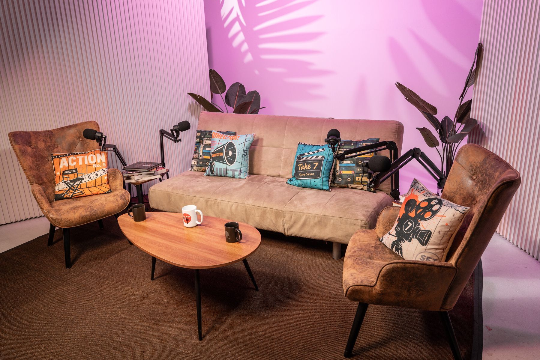 Lounge podcast set with pink lighting, sofa and microphones, KSM Podcast Studio Miami