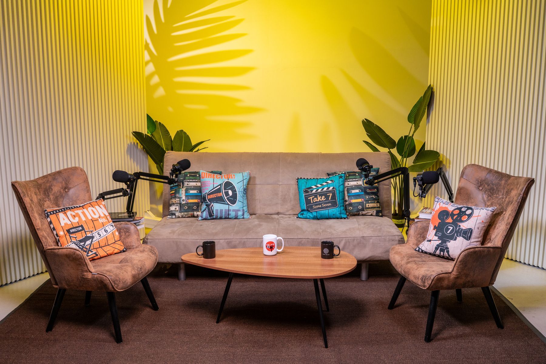 Lounge podcast set with sofa and armchairs for 3–4 guests, yellow lighting, Miami podcast studio