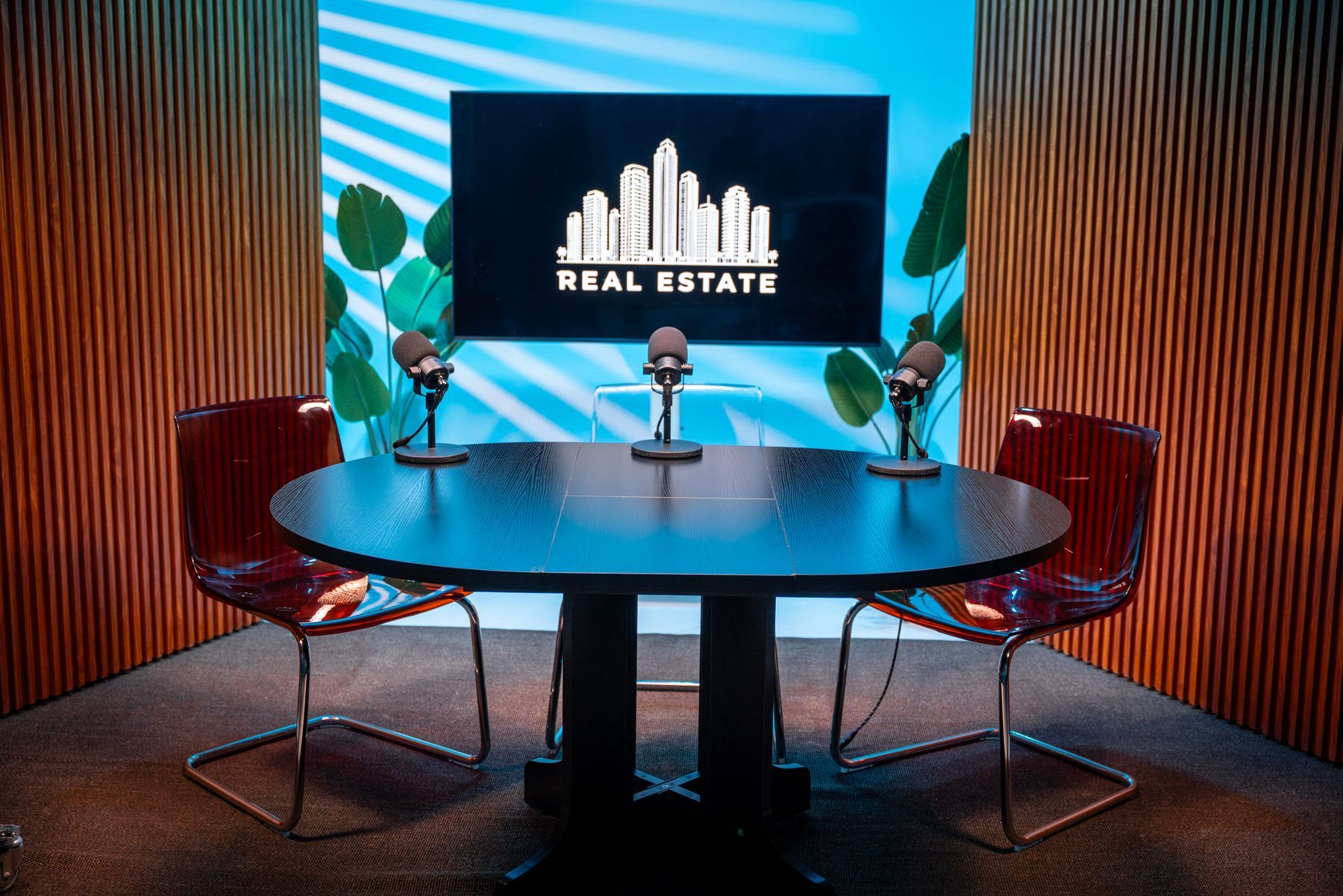 Roundtable podcast set with blue lighting and branded screen for corporate podcasts in Miami