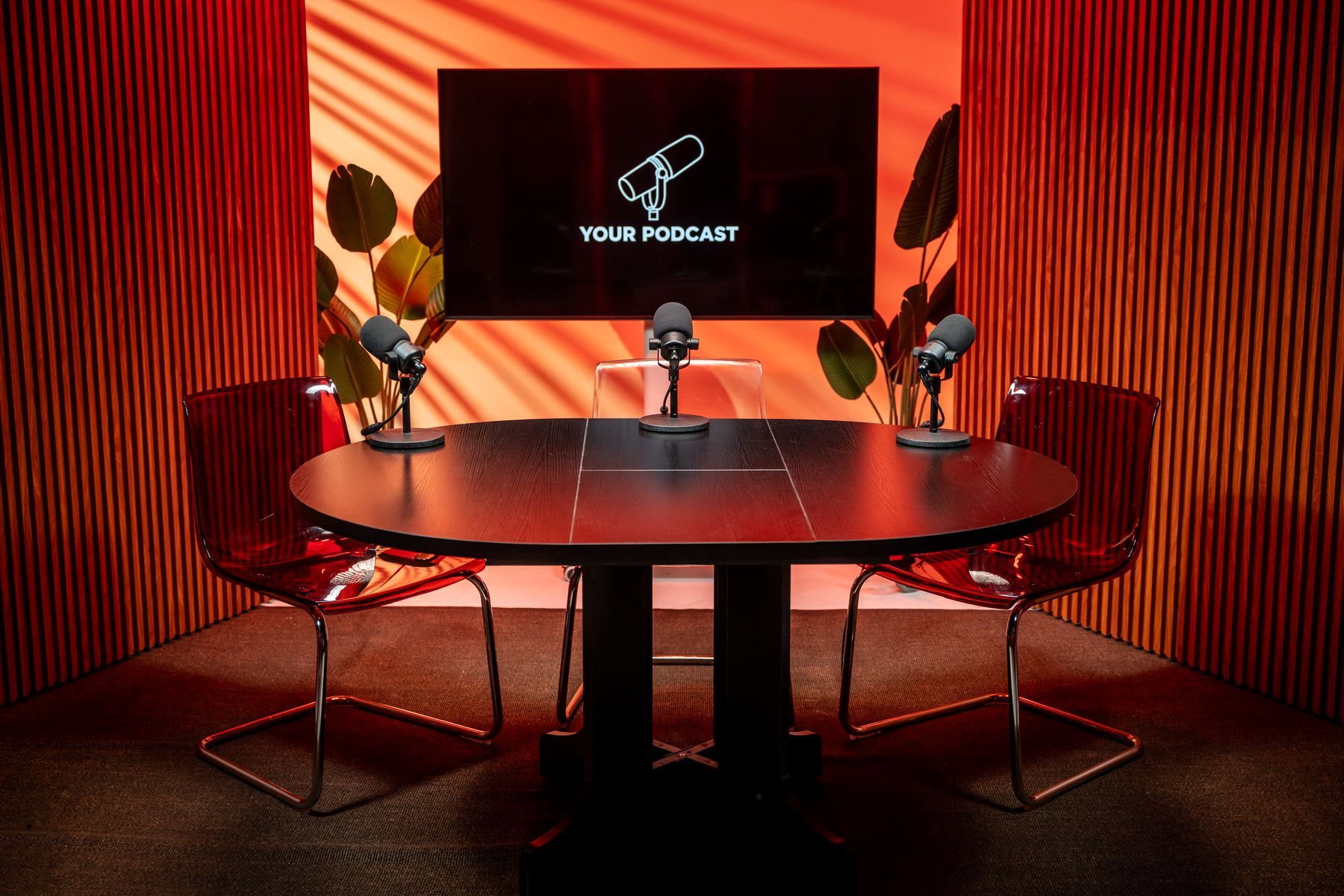 Roundtable video podcast set with orange lighting, microphones and branded screen at KSM Podcast Studio in Miami